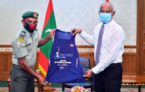 Marathoner Nasrullah Ahmed presents his 60th medal and jersey to the President